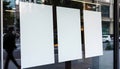 Three blank white posters are displayed in a storefront window, presenting promotion space. AI Generated Royalty Free Stock Photo