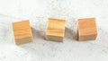 Three blank wooden playing cubes on white board