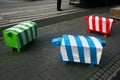 Three blocky animal sculptures. Colorful sheep traffic safety bollards on stone pedestrian sidewalk in Christchurch, New Zealand