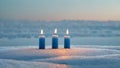 Three blue candles sit atop a snowy surface Royalty Free Stock Photo