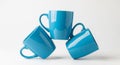 Three Blue Ceramic Mugs Stacked in a Pyramid Formation on a White Background cups teal Royalty Free Stock Photo