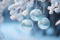 three blue christmas ornaments hanging from a branch in the snow Royalty Free Stock Photo