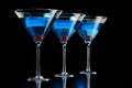 Three blue cocktails with cherry on black Royalty Free Stock Photo