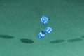 Three blue dices falling on a green table Royalty Free Stock Photo