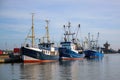 Three blue fishing boats at the quay in the port of Buesum on the North Sea in Germany against the blue sky, copy space