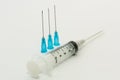 Three blue needles and one 5ml disposable plastic syringe Royalty Free Stock Photo