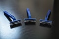 Three blue razors on a wooden background Royalty Free Stock Photo