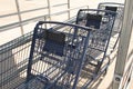 three blue shopping grocery carts outside outdoors in summer loosely inside each. p