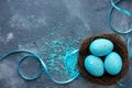 Three blue speckled eggs in bird nest , Easter holiday decorations