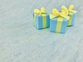 Three blue square gift boxes on the corner on blue green gray watercolor textured background, copy space. Royalty Free Stock Photo