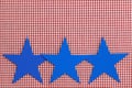 Three blue stars border red checkered (gingham) background Royalty Free Stock Photo