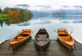 Three boats moored on Bled lake at foggy autumn day Royalty Free Stock Photo
