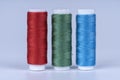 Three bobbins of sewing thread of red green and blue colors isolated on white Royalty Free Stock Photo