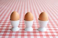 Three boiled eggs in egg cups Royalty Free Stock Photo
