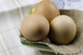 Three boiled eggs are on a piece of linen fabric