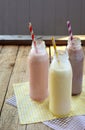 Three bottle of various milkshakes chocolate, strawberry and vanilla . Healthy smoothie with straw. Tasty milk shake cocktails. Re Royalty Free Stock Photo