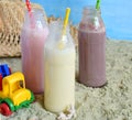Three bottle of various milkshakes chocolate, strawberry and vanilla . Healthy smoothie with straw. Tasty milk shake cocktails. Re Royalty Free Stock Photo