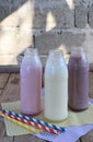 Three bottle of various milkshakes chocolate, strawberry and vanilla . Healthy smoothie with straw. Tasty milk shake cocktails. Re Royalty Free Stock Photo