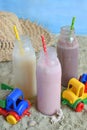 Three bottle of various milkshakes chocolate, strawberry and vanilla . Healthy smoothie with straw. Tasty milk shake cocktails. Re Royalty Free Stock Photo