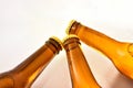 Three bottlenecks filled with fresh beer closed on white table Royalty Free Stock Photo
