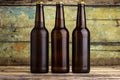 Three bottles of beer against wooden background