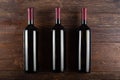 Three bottles of red wine on a wooden background. View from above Royalty Free Stock Photo