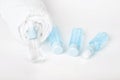 Three bottles of tonic or lotion blue color and white towel on white background Royalty Free Stock Photo