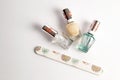 Three bottles of clear nail polish with emery board on white surface Royalty Free Stock Photo