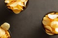 Three bowl of crispy potato chips on brown stone background.