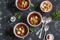 Three bowls of gazpacho soup on a dark background. Healthy vegetarian food.