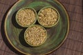 Three bowls of oat grains on a green plate. Brown background. Top view Royalty Free Stock Photo