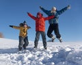 Three boy family friends joyfully jump into the sky over snow drifts in the winter, children play Royalty Free Stock Photo