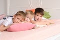 three boys lying on a bed