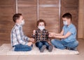 three boys play at home in medical masks