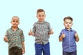 Three boys are standing together on the white background and hold their thumbs up Royalty Free Stock Photo