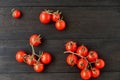 Three branches of red cherry tomatoes isolated on black wooden background Royalty Free Stock Photo