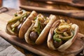 Three bratwurst sausages with grilled onions and bell peppers Royalty Free Stock Photo