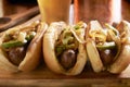 Three bratwurst sausages with grilled onions and bell peppers Royalty Free Stock Photo