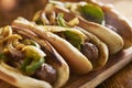 Three bratwurst sausages with grilled onions and bell peppers Royalty Free Stock Photo