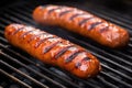 three bratwursts with crisp grill marks on a bbq grill Royalty Free Stock Photo