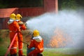 Three brave firefighter using extinguisher and water from hose for fire fighting, Firefighter spraying high pressure water to fire