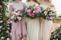 Three bridesmaids holding in hands beautiful flower bouquets in pink colors Royalty Free Stock Photo