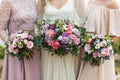 Three bridesmaids holding in hands beautiful flower bouquets in pink colors Royalty Free Stock Photo