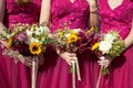 Three bridesmaids in lilac lace dresses with bouquets of fresh flowers, selective focus Royalty Free Stock Photo