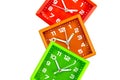 Three bright alarm clocks on a white background. Alarms green, orange and red.