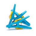 Three bright blue plastic clothespins with yellow spring mechanisms arranged in a cluster on a white background Royalty Free Stock Photo