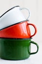 Three bright colorful enameled mugs Royalty Free Stock Photo