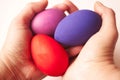 Three bright multycolored eggs in hands