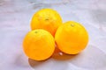 Three bright oranges in a minimalist composition on a smooth marble surface. Royalty Free Stock Photo