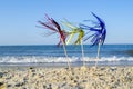 Three bright shiny colored cocktail decorations on stick stand in sand near sea Royalty Free Stock Photo